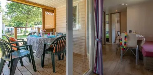 Mobil Home Confort 3 Chambres 6 personnes - Camping Paradis L'Europe : salon avec table et chaises extérieures