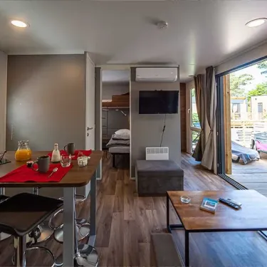 Mobil Home Hélios 2 Chambres 5/7 Personnes - Camping Paradis - Intérieur avec table, canapé et lit