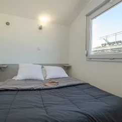 Chambre du bungalow Alizé, lit double, vue sur le camping Paradis