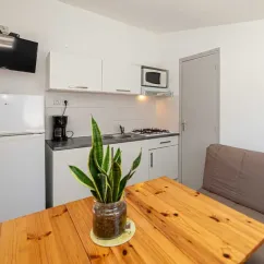 Cuisine du bungalow Alizé, réfrigérateur, micro-ondes, table en bois