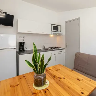 Cuisine du bungalow Alizé, réfrigérateur, micro-ondes, table en bois