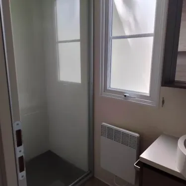 Salle de bain du Mobil Home Grand Confort Tulipe, douche et radiateur