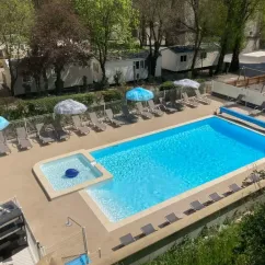 Piscine avec chaises longues et parasols au Camping Les Rives d'Auzon