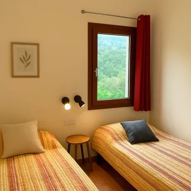 Chambre avec deux lits simples, fenêtre et rideau rouge - Cottage Premium - Camping Village de Vacances Camboussel