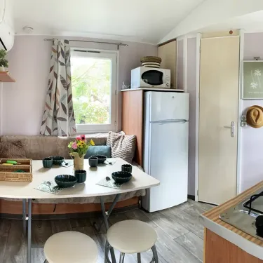Mobil Home Malin 2CH 4P - Camping Val de Cesse : salle à manger avec table et frigo