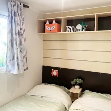 Mobil Home Welcome 3CH 6P - Camping Val de Cesse : chambre avec deux lits et décoration 'FAMILY'