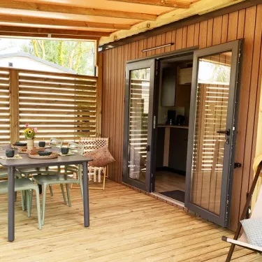 Mobil Home Premium 2CH 4P - Camping Val de Cesse : terrasse en bois avec table et chaises