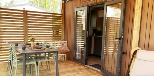 Mobil Home Premium 2CH 4P - Camping Val de Cesse : terrasse en bois avec table et chaises
