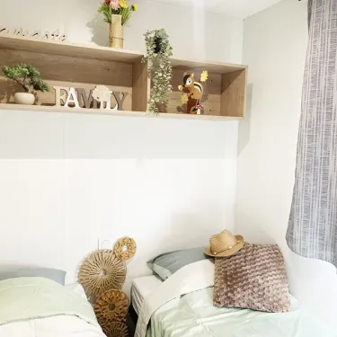 Mobil Home Premium 3CH 6P - Camping Val de Cesse : chambre avec lits et décoration
