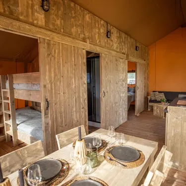 Salle à manger et lit superposé dans le Glamping Lodge Premium 2CH 4P, Camping Val de Cesse