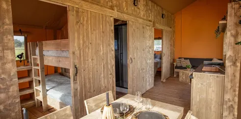 Salle à manger et lit superposé dans le Glamping Lodge Premium 2CH 4P, Camping Val de Cesse