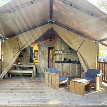 Camping Val de Cesse - Lodge River Premium 2CH 4P : tente avec salle à manger et canapé extérieur