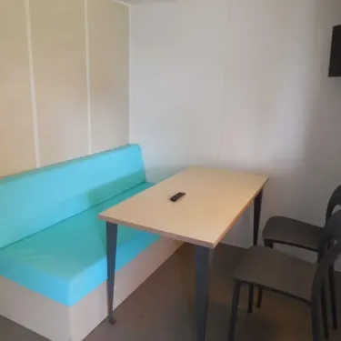 Mobil Home 2 Personnes - Camping du Lac Terre d'Auge : canapé bleu, table et chaises