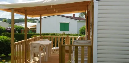Mobil Home 2 Personnes - Camping du Lac Terre d'Auge : terrasse en bois avec table et chaises