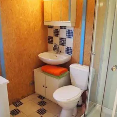 Salle de bain du bungalow Le Lavandin avec lavabo, toilettes et douche.