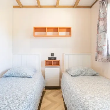 Chalet Sésame 3Ch - 6P - Camping Les Peupliers : chambre avec deux lits