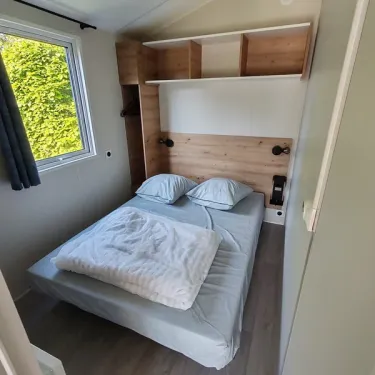 Mobil Home Bergame 2Ch - 4P - Camping Les Peupliers, chambre avec lit et étagères