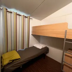Chambre avec lit simple et lit superposé dans le camping Paradis Family