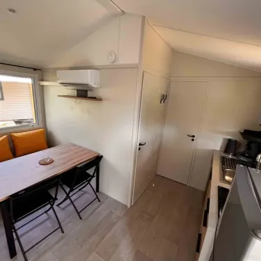 Mobil Home Confort 2 Chambres 4 Personnes Clim TV - Paradis Family les Rives de l'Hérault : salle à manger avec canapé et table