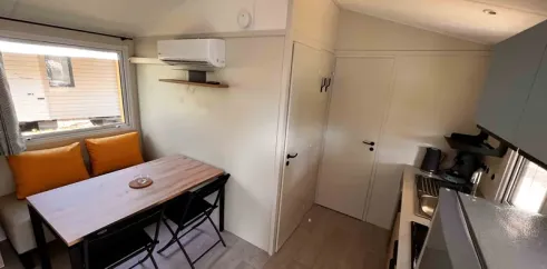 Mobil Home Confort 2 Chambres 4 Personnes Clim TV - Paradis Family les Rives de l'Hérault : salle à manger avec canapé et table