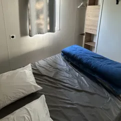 Chambre du Mobil Home Confort 3 Chambres 6 Personnes Clim TV - Paradis Family les Rives de l'Hérault avec lit et couette