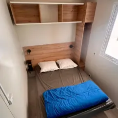 Chambre avec lit double, étagères et fenêtre - Mobil Home Premium 4 Chambres 8 Personnes - Paradis Family les Rives de l'Hérault