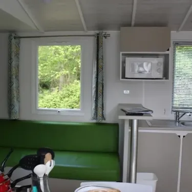 Mobil Home Confort 3 Chambres 6 Personnes - le Rompval : intérieur avec canapé vert