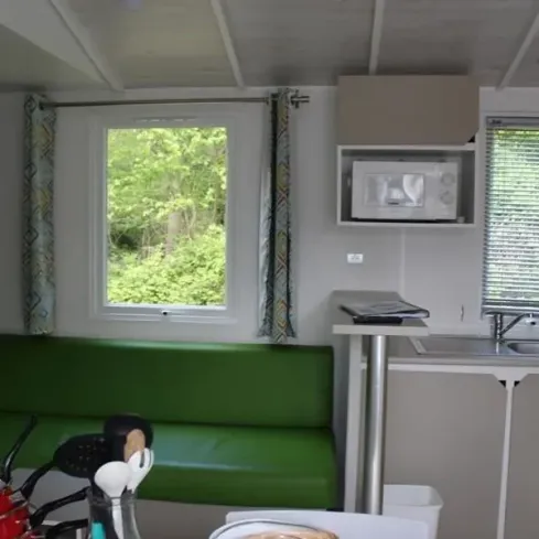 Mobil Home Confort 3 Chambres 6 Personnes - le Rompval : intérieur avec canapé vert
