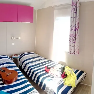 Chambre avec deux lits simples et guitare dans Mobil Home Belle Ile