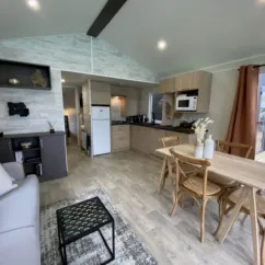Intérieur mobil home avec cuisine, salle à manger et salon