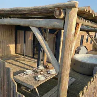 Terrasse en bois avec jacuzzi et table pour déjeuner