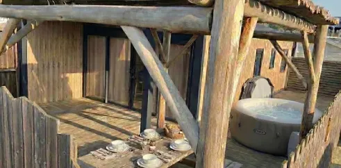 Terrasse en bois avec jacuzzi et table pour déjeuner