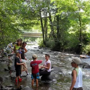 Camping Le Moulin de Serre : enfants qui pêchent dans une rivière en forêt