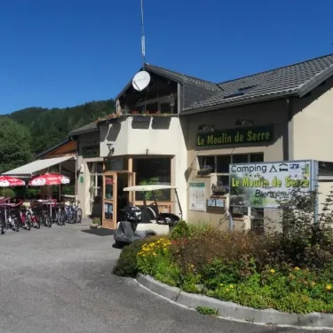 Entrée du Camping Le Moulin de Serre avec vélos, parasols et voiturette de golf