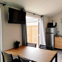 Mobil Home Fidji Premium - salle à manger avec table, chaises et télévision