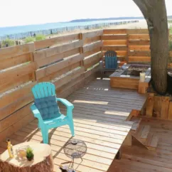 Terrasse en bois avec chaise bleue, table et vue sur la mer - Mobil Home Sunset Premium