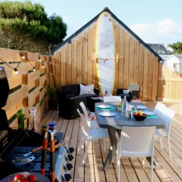 Terrasse avec table, chaises, barbecue et surfboard - Mobil Home Sunset Premium