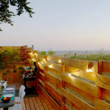 Terrasse éclairée par des guirlandes, table et chaises - Mobil Home Sunset Premium