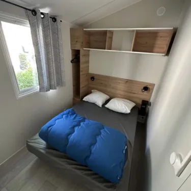 Mobil Home Confort 2 Chambres 4 Personnes - Family's Camping Le Savoy : lit, étagères, fenêtre