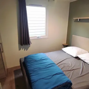 Mobil Home Confort 2 Chambres 4 adultes et 2 enfants - Family's Camping Le Savoy : lit, rideau, fenêtre