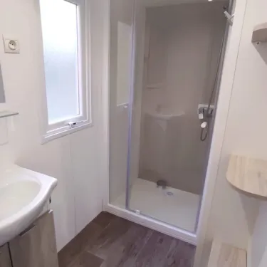 Salle de bain avec douche, lavabo et fenêtre - Mobil Home Confort - Family's Camping Le Savoy