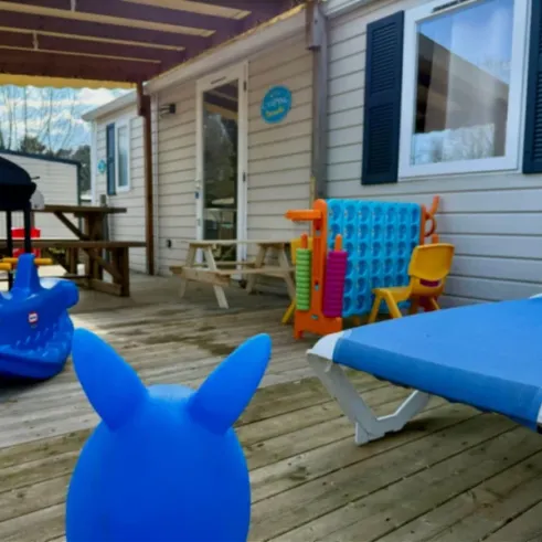 Terrasse avec jeux pour enfants, chaises longues et table - Paradis Family des Issoux