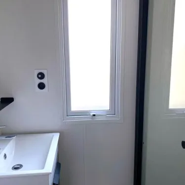 Mobil Home 3 Chambres 6/8 Personnes - Paradis Family des Issoux : salle de bain avec lavabo et fenêtre