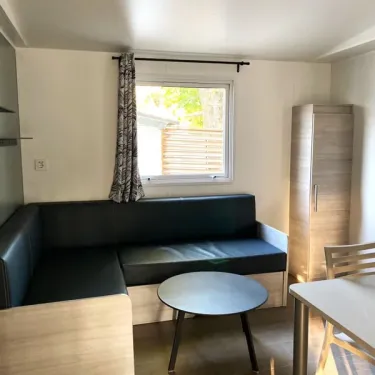 Salle de séjour du Mobil Home Paradis Family des Issoux avec canapé et table