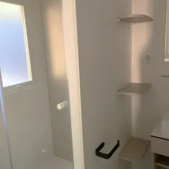 Salle de bain avec étagères murales et lavabo - Mobil Home Paradis Family des Issoux