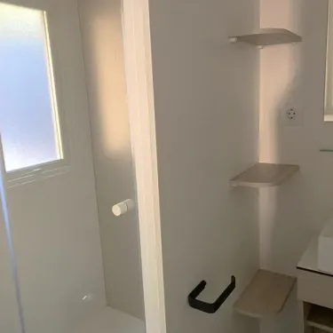 Salle de bain avec étagères murales et lavabo - Mobil Home Paradis Family des Issoux
