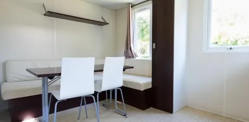 Mobil Home Confort Nobis 1 Chambre 2 Personnes - Camping Paradis Les Nobis d'Anjou : coin repas et canapé