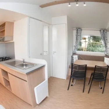Intérieur Mobil Home Eden Thouet avec cuisine, table à manger et chaises.