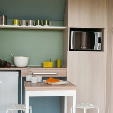 Coco Sweet Confort 2 Chambres 4 Personnes Sans Sanitaires - Camping Paradis Les Nobis d'Anjou : cuisine compacte avec micro-ondes et table.