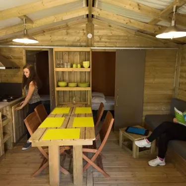 Intérieur du cottage Anjou avec table, chaises et coin repas